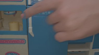 Canlı, küçük bir mutfaktaki minyatür bir buzdolabına uzanan el, kurgunun büyüleyici detaylarını gözler önüne seren bir yemek etkinliğine hazırlanıyor..