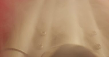 Dalgalı kırmızı kumaş ve hafif dumanlı saç maşasının detaylı görüntüsü..