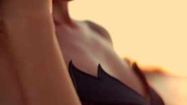 Uzun kız sahilde duruyor güneş yükselirken ılık okyanus dalgaları yavaşça kıyıya vuruyor huzurlu bir an yaratıyor doğal güzellikleri dolduruyor.