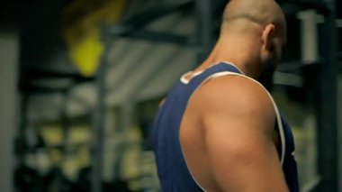 Kel atletik sakal, ağırlığını bacak pres makinesine veriyor. çevre çeşitli fitness ekipmanlarıyla donatılmıştır.