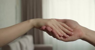 Erkek eli, kadın eline kapı anahtarlarını uzatarak sorumluluk ya da mülkiyet transferini gösterir. Doğal ışık, yakınlardaki bir pencereden süzülerek sıcak bir atmosferi yükseltir..