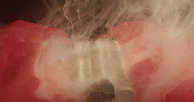 Kırmızı şifonlu, dalgalı ve dumanlı bir saç maşası. Yakın plan.