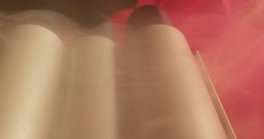 Kırmızı bir kumaşta dumanlı dalgalı saç yapmak için saç maşası yakın plan..