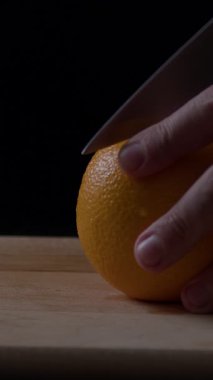 Adamın eli portakalı sıkı sıkı tutuyor. Keskin bir bıçakla parlak narenciye meyvesini ustalıkla kesiyor. Hava sıcak ve davetkar..