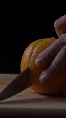 Adamın eli parlak bir portakalın üzerinde ustalıkla meyvenin içini açarken duruyor. Mutfak sıcacık aydınlatılmış. Hoş bir atmosfer yaratıyor..