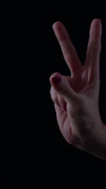 Zafer ve pozitifliği sembolize eden klasik bir zafer jestinde el kaldırır. Zafer temasını vurgulayan zıt bir karanlık zemine karşı yapılan jest vurgulandı.