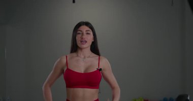 Sportif kız spiker, enerjisini ve coşkusunu kameraya yansıtıyor. İzleyicilerle bağlantı kurduğu bir stüdyoda, spor programları ve motivasyonu vurguluyor..