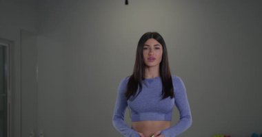 Sportif bir kız spiker modern bir spor stüdyosunda kendine güvenen bir tavır sergiliyor. Onun canlı kıyafeti ve anlamlı jestleri olayın heyecanını yakalar..