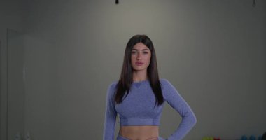 Sportif kız spiker, spor salonu ortamında spor ve atletizmi vurgulayarak seyirciye canlı yorumlar yaparak yeteneklerini sergiliyor..