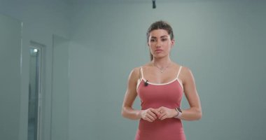 Sportif kız spiker kendine güvenerek kameraya konuşuyor ve iyi aydınlatılmış bir stüdyoda spor tavsiyelerini paylaşıyor. İzleyicilerle iletişim kurarken coşku ve enerji yayıyor..