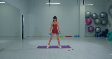 Sporcu, Romanya 'da geniş bir duruş sergileyen halterle kaldırma kuvvetini gösteriyor ve iyi donanımlı bir spor salonuna odaklanıyor. Ayarlar egzersiz paspasları ve fitness ekipmanlarını içeriyor.