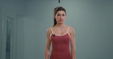 Sportif kız spiker kameraya konuşurken kendinden emin duruyor. Enerjik tavırları, spora olan tutkusunu ve coşkusuyla seyircileri büyülediğini gösteriyor..