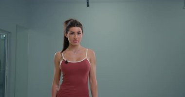 Sportif kız spiker güvenle ayakta duruyor ve kameraya konuşuyor. O bilgilendirici içeriği sunarken, onun odak ve coşkusu izleyicileri kendine çekiyor..