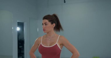 Genç bayan sporcu, açık bir spor salonunda çeviklik ve koordinasyon becerilerini geliştirmek için antrenman yaparken başını çeviriyor..