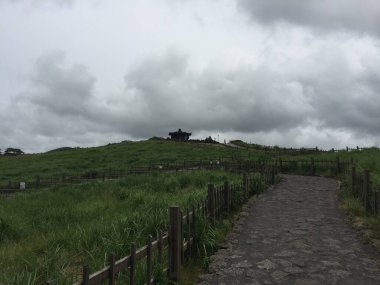 Jeju, Güney Kore 'de gökyüzü bulutlu Sangumburi manzarası