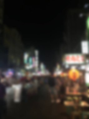 Tayvan 'daki yürüyen sokak gece pazarının bulanık arka planı. Turist alışveriş ve yemek için gece marketinde yürüyor.