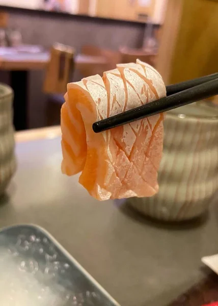 Sashimi Close Zalm Buik Houden Door Eetstokjes Japans Restaurant Achtergrond — Stockfoto