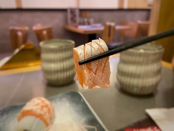 Sashimi Close Salmon Belly Hold Chopsticks Japanese Restaurant Background — Stock Photo, Image