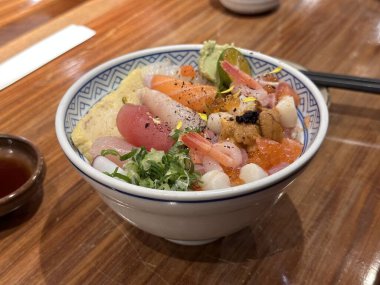 Taze çiğ deniz ürünleri karışık pirinç kasesi. Kaisen-Don. Japon pilavı, karides, ton balığı, somon, deniz kestanesi, karides ve diğer balıklardan oluşan sashimi. Kapat..