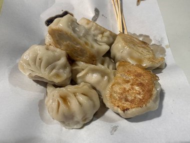 Yağlı kağıtta ince bambu çubuklarıyla kızartılmış hamur köftesi. Çin yemeği tarzı..