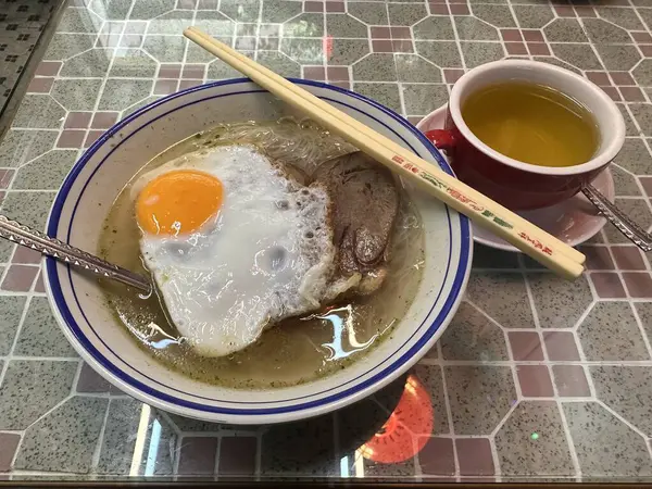 Cantonese food, rice noodles with sunny-side-up egg and Pan-fried beef tongue. a cup of hot chrysanthemum honey. Hong Kong cha chaan teng style.