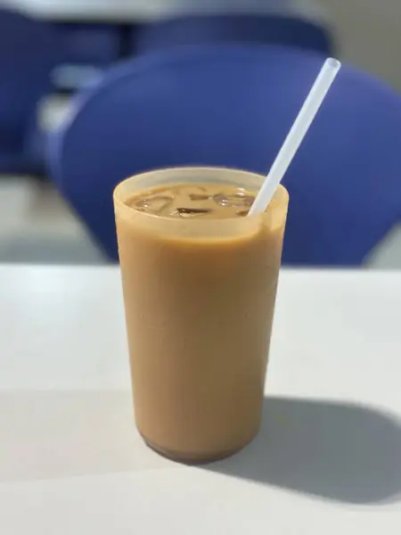 Cantonese food, Hong Kong style ice milk tea with drinking straw on table.