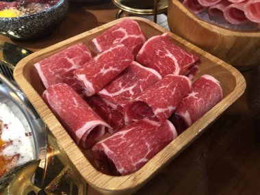 Sıcak tencere için sığır eti rulosu, ahşap tabak, taze dilimlenmiş çiğ et, rulo ile tanışın.