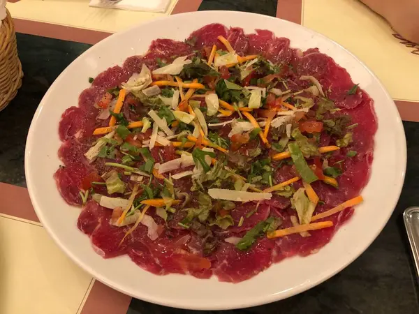 Geleneksel sığır carpaccio peynirli ve salatalı seramik tabak, çiğ et, İtalyan mutfağı.