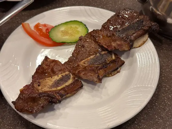 Kızarmış sığır kaburgası ve yanında tabak.