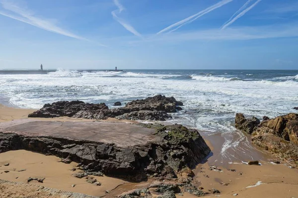 Dalgalarla çevrili deniz fenerleri manzaralı Rocky sahili.