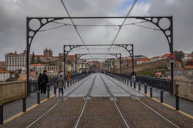 Porto, Portekiz - 13 Mart 2023: İkonik metal Luis I köprüsü üzerinde yürüyen az sayıda insan, tarihi merkeze kadar