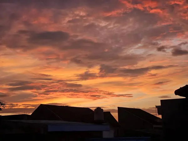 Gökyüzü bulutlarla dolu güzel bir gün doğumu manzarası. Gün doğumunun yerleşim alanı üzerindeki görüntüsü.