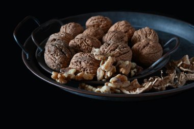 Tüm ve açık çiğ cevizler siyah arka planda izole edilir.