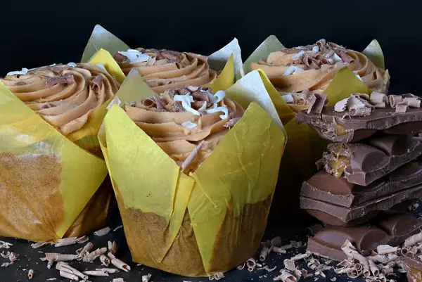 Muffinler çikolatalarla mükemmel eşleştirilmiş, siyah arkaplan