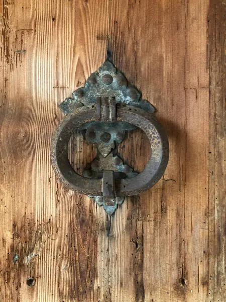 Eski bir metal kapı tokmağı Eski bir ahşap kapının önünde