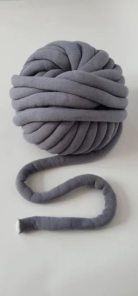 Tıknaz pamuk ipliği organik pamuktan yapılmış ve içinde polyester var. Beyaz arka planda büyük gri iplik. Boyutunda dikiş yok, sürekli tüp ipliği..