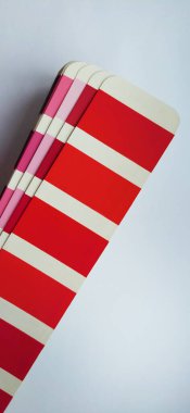 Renkli Pantone laboratuarı. Beyaz arka planda kırmızı ve pembe palet. Renk oluşturma sistemi, kırmızı ve pembe renk tonlarına sahip bir vantilatör.