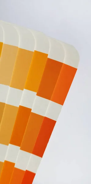 Pantone Renk Eşleştirme Sistemi. Beyaz arka planda turuncu palet. Renk oluşturma sistemi, beyaz arkaplanda turuncu renk tonlarına sahip bir yelpaze.
