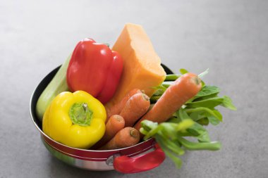 Kırmızı bir tencerede çorba için taze sebze yakın plan.