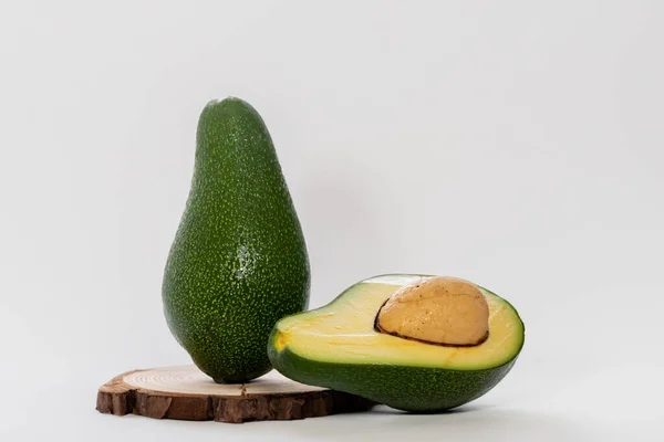 Avocadohälfte Auf Holzteller Gegen Weißes Holz — Stockfoto
