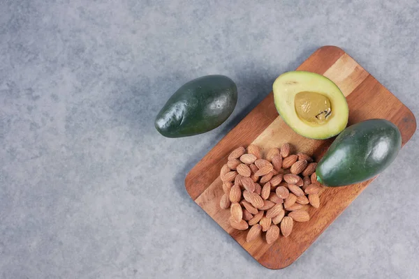 Avocado slice and almond nut on chopping board