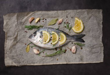Parşömen kağıdında baharatlı çiğ dorado balığı.