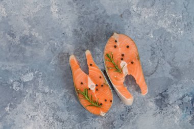 Köy ahşap kesme tahtasında mis kokulu bitkilerle taze somon bifteği lezzetli bir yemek hazırlama sanatı.