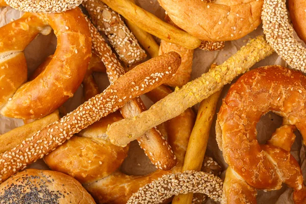 stock image Different kinds of fresh bread, breadsticks, bagel and pretzel as background. Top view. Copy space