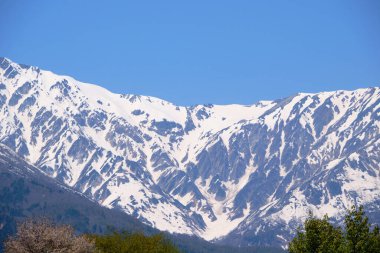 Hakuba, Japonya 'da güneşli bir bahar gününde dağ zirveleri manzarası