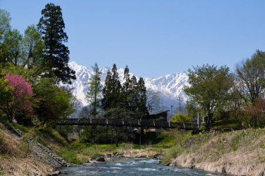 Hakuba 'nın Hakuba köyündeki karla kaplı dağları Himekawa Nehri' ne döküyor.