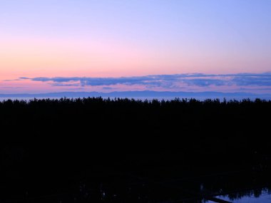 Japon Denizi üzerinde gün batımı ve pirinç tarlalarının yansımaları