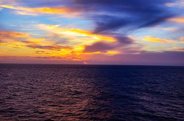 Renkli bulutlar ve gökyüzü ile denizde inanılmaz bir gün batımı. Okyanusun üzerinde renkli gün batımı.