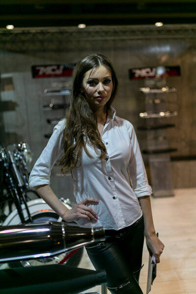 Милан, Италия - 2021 11 27: Eicma Milano Expo красивая черноволосая девушка на велосипеде. Высокое качество фото