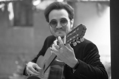 Gitarist müzisyen bir pencere kenarında tellerle gitar çalar. Yüksek kalite fotoğraf